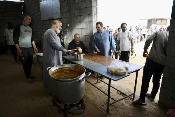 Libyan volunteers serve free traditional unleavened Libyan bread made out of barley for passing fasting people in Tajoura, east of Libya's capital Tripoli, Tuesday, March 11, 2025, during the Muslim holy month of Ramadan. (AP Photo/Yousef Murad)