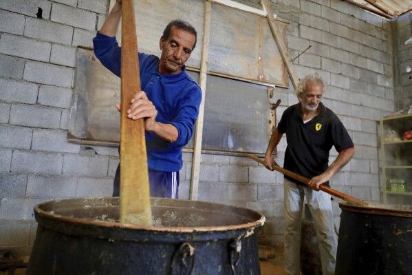 Libyan volunteers prepare Bazin, traditional Libyan dough bread made of barley or whole wheat flour and often served with stew in Tajoura, east of Libya's capital Tripoli, Tuesday, March 11, 2025, during the Muslim holy month of Ramadan. (AP Photo/Yousef Murad)