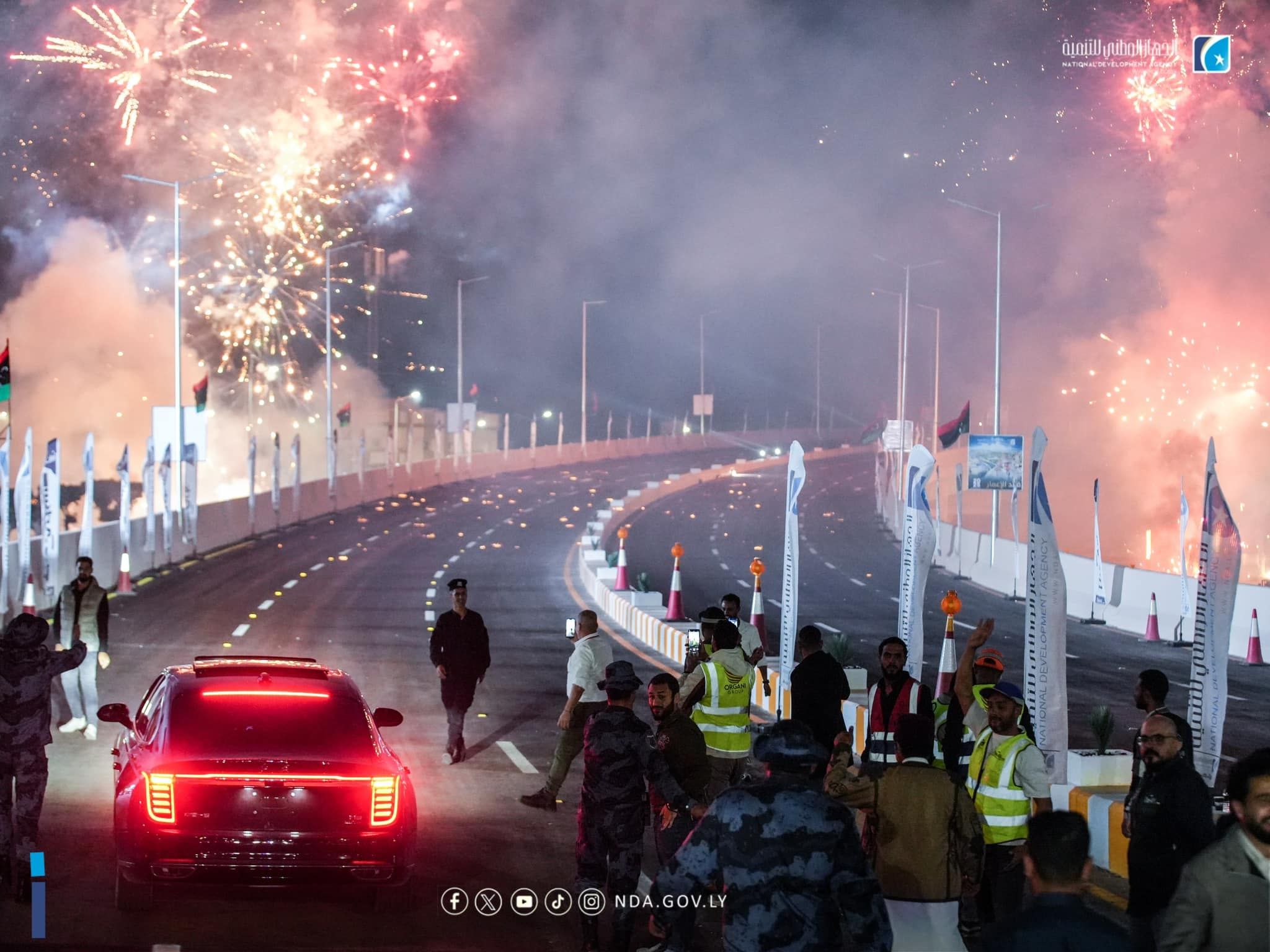 May be an image of 11 people, fire, crowd, road, fireworks and text